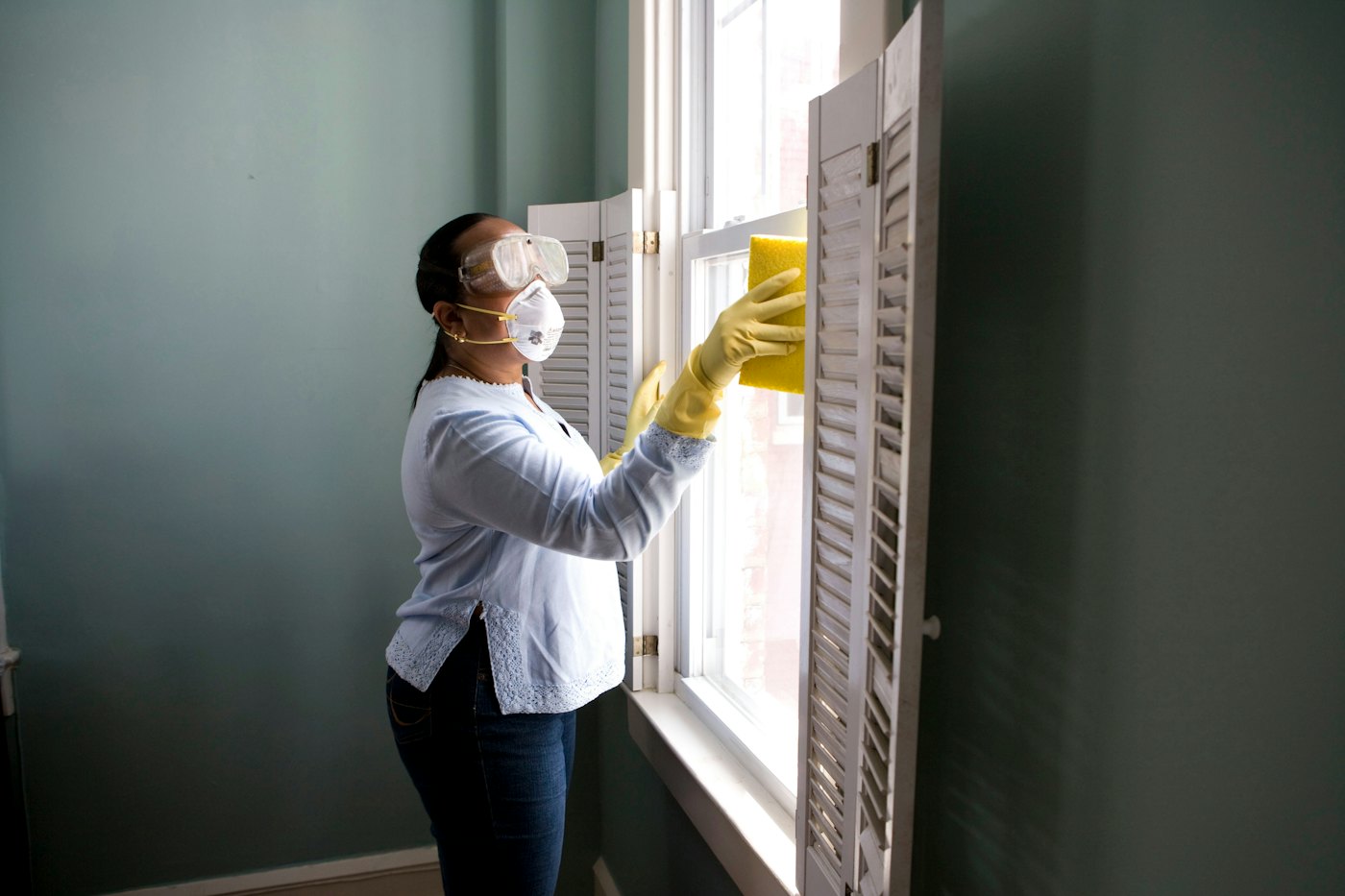 Cleaner wiping a window during a residential home cleaning